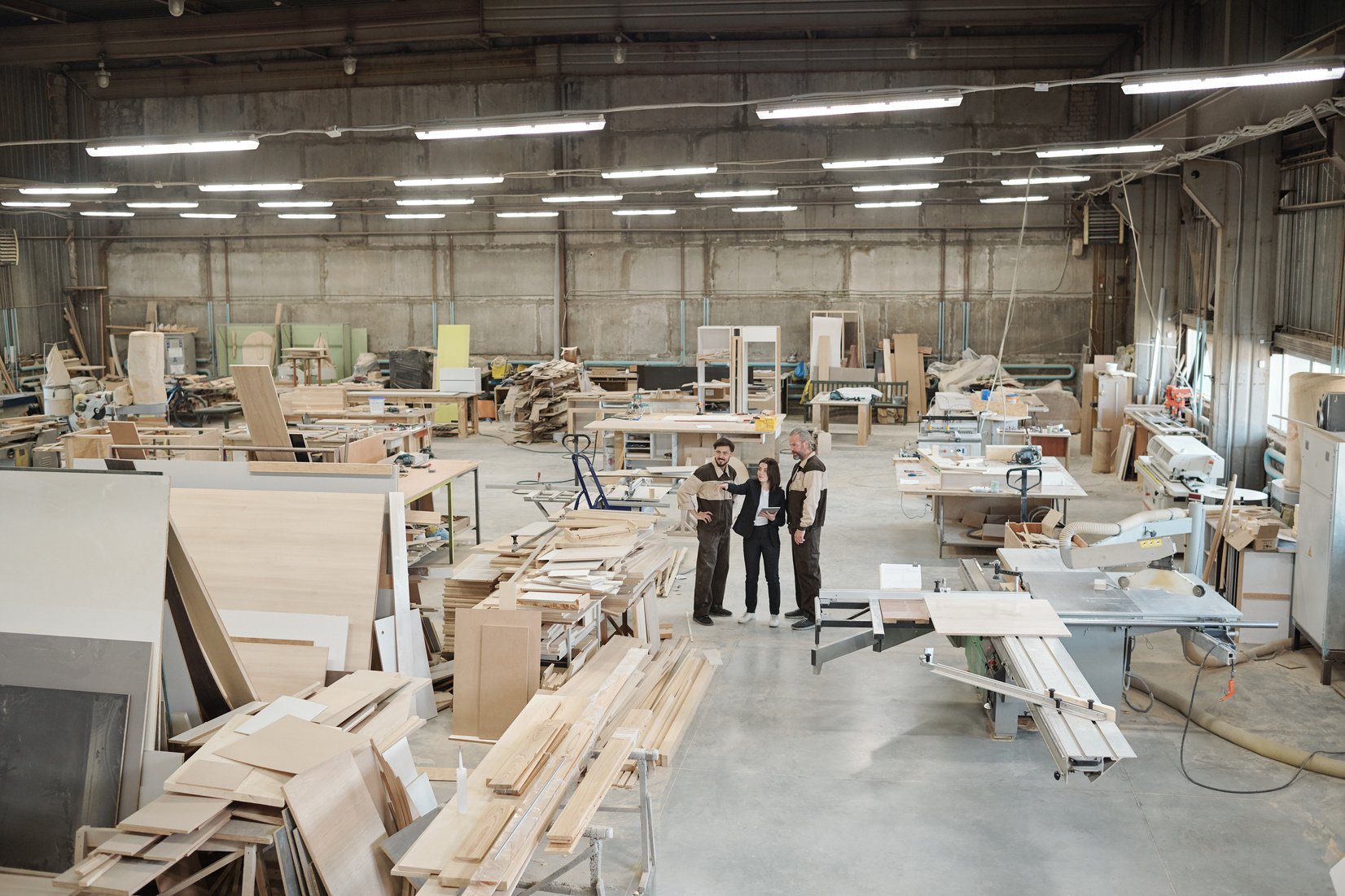 Group of Contemporary Factory Workers Discussing Furniture Producing Materials